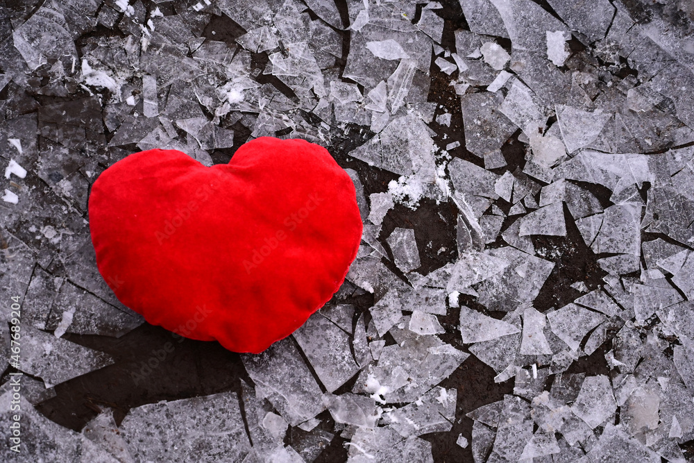 Obraz premium A red heart in shards of ice. Unrequited love, infidelity