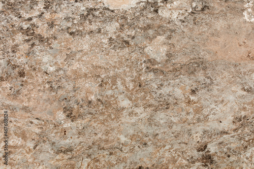 Natural stone texture. Closeup of layered rough grainy rock surface. Flat lay, top view. Different shades of brown. Copy space. 