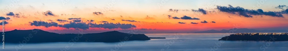 Nea Kameni island and Oia village at sunset in Santorini. Greece