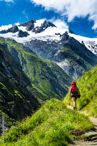 Hiking Young Woman In Valley Of Umbalfaelle On Grossvenediger With View To Mountain Roetspitze In Nationalpark Hohe Tauern In Tirol In Austria