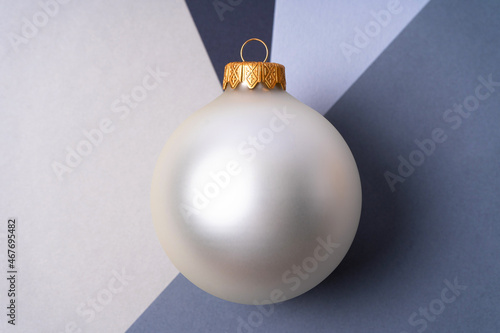 A large silver Christmas ball at the intersection of shades of gray. Christmas and New Year concept. Close up