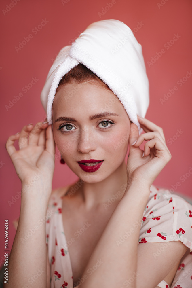 Close-up of pretty girl with towel wrapped hair and with red lipstick looking at camera on isolated background. Young fair-skinned lady with freckles after shower. Hair care concept. Close-up of pretty girl with towel wrapped hair and with red lipstick looking at camera on isolated background. Young fair-skinned lady with freckles after shower. Hair care concept.