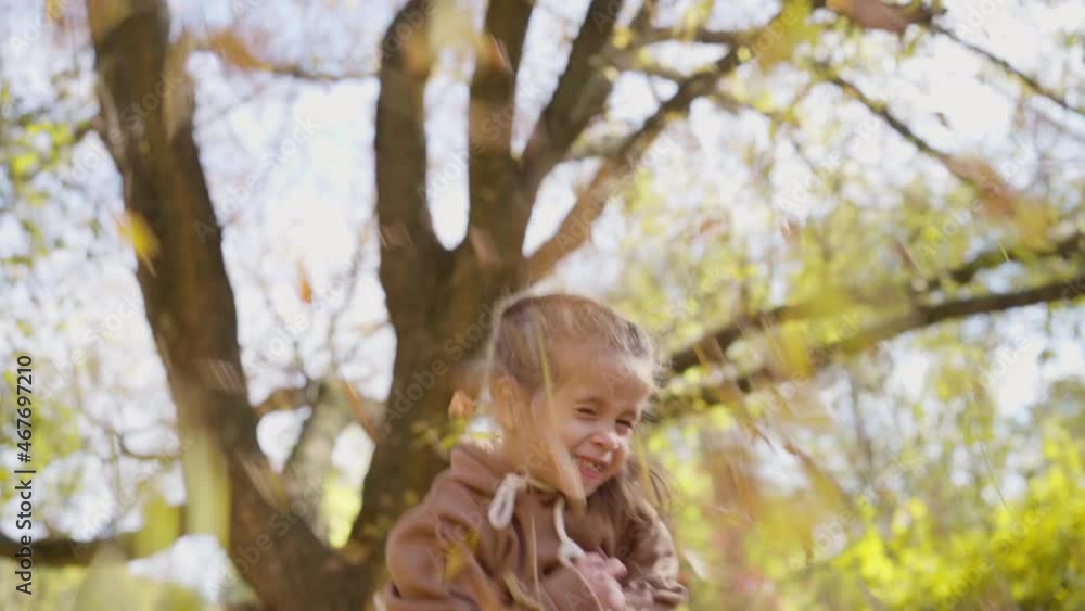 Girl throws autumn yellow leaves up and laughs, kid is having fun playing city nature park outdoors, Caucasian female little child positive emotions Happy childhood Girl throws autumn yellow leaves up and laughs, kid is having fun playing city nature park outdoors, Caucasian female little child positive emotions Happy childhood
