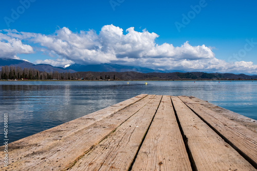 Fotografía wooden pier on the lake, blue cloudy sky and mountain landscape