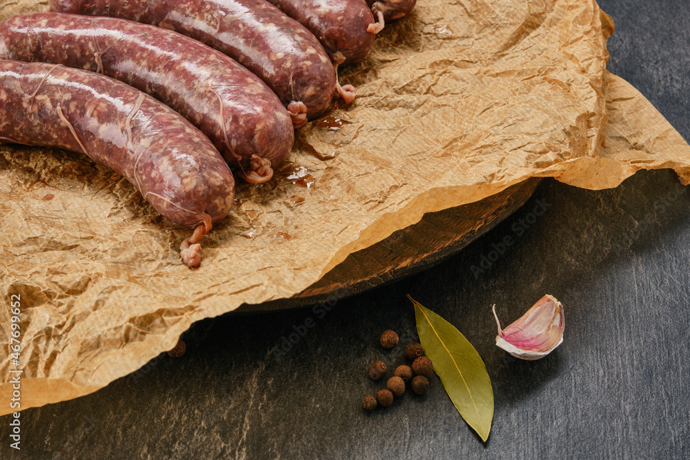 Freshly made raw breed butchers sausages in skins on crumpled paper and