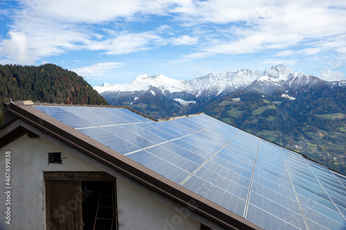 solar power system on barn roof in the mountains, renewable energy