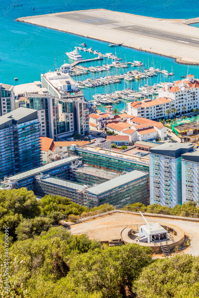 Fototapeta premium Gibraltar city and bay panoramic view from the Rock of Gibraltar with downtown, airfield and artillery battery in the foreground