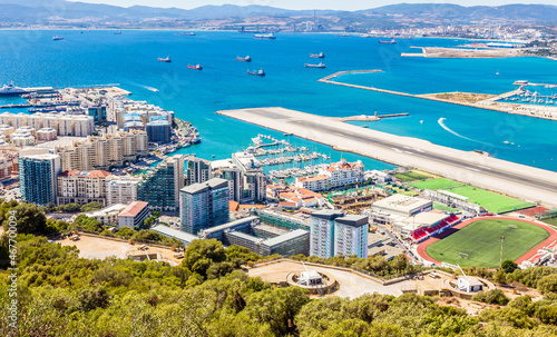 Gibraltar city and bay panoramic view from the Rock of Gibraltar with downtown, airfield and artillery battery in the foreground
