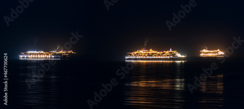 Stranded, brightly lit cruise liners in Weymouth Bay at night © allouphoto