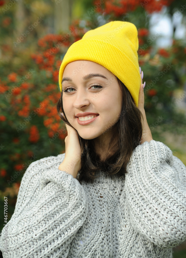 Beautiful smiling woman in yellow hat in the autumn park. Beautiful smiling woman in yellow hat in the autumn park.