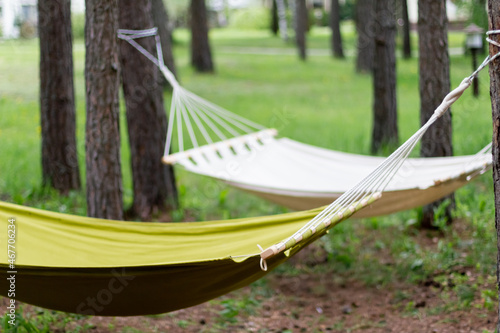 White and green hammock in garden, close-up. Empty hammock for relaxing