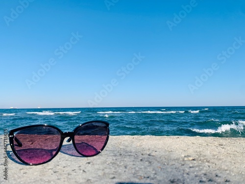 sunglasses on the beach on sea background © Yulia
