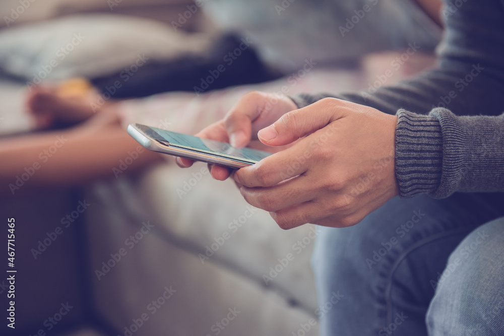 Young woman sitting using smartphone on sofa at home.