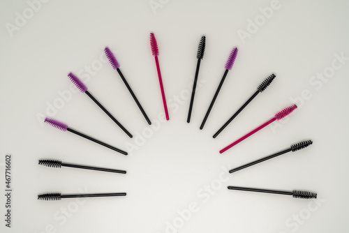Makeup brushes, eyelash combs and eyebrows on white background with copy space