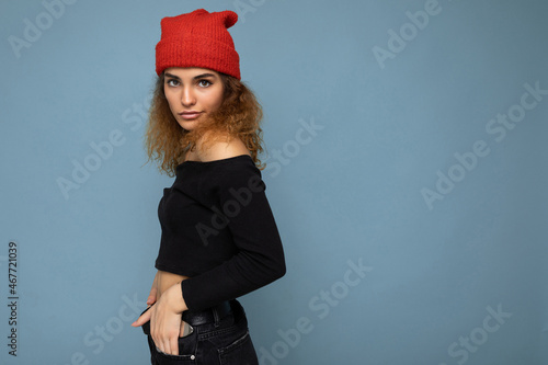 Beautiful young brunette woman isolated over blue background wall wearing casual stylish clothes feeling sincere emotions lookingat camera photo