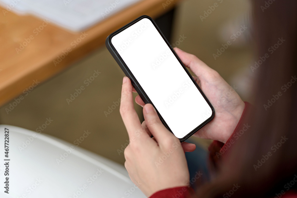 Close-up of a businesswoman hand holding a smartphone blank white screen enjoy social media applications ads. Mock up.