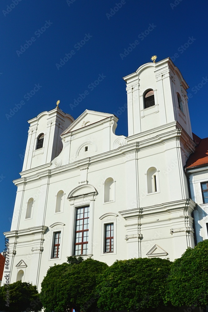 Front view of baroque Jesuit Church Of Saint Francis Xavier in Skalica from year 1693, sunlit by afternoon summer sunshine, clear blue skies in background.