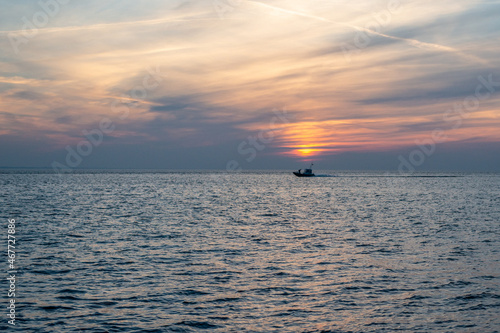 Sunset in the sea with boat silhouette