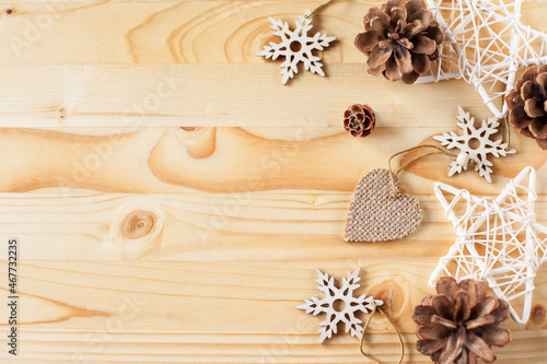 christmas background. Cones, stars and wooden figures in snowflakes on a light wooden background
