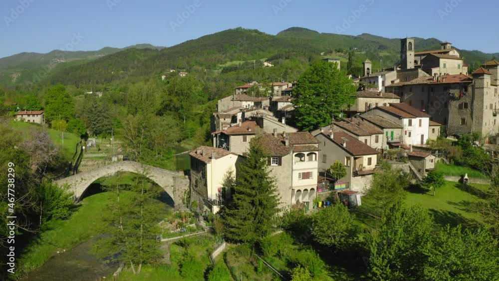 Aerial Beautiful Shot Of Roofed Houses On Hills Landscape, Drone Flying Upwards Over Trees In Sunlight - Apennine Mountains, Italy Aerial Beautiful Shot Of Roofed Houses On Hills Landscape, Drone Flying Upwards Over Trees In Sunlight - Apennine Mountains, Italy