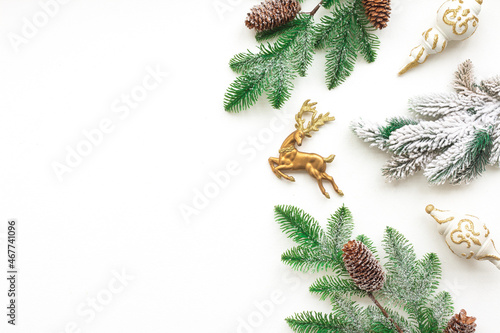 Gold Christmas decoration, pine cone branches on white background, flat lay, top view