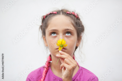 Little girl sniffing yellow flower