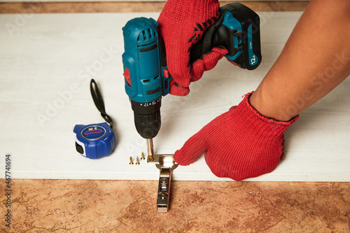 Foto Installation of furniture hinges in the kitchen cabinet door