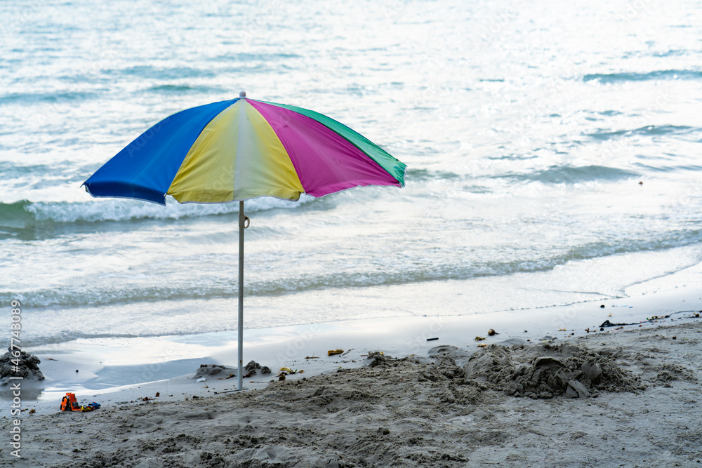 umbrellas of various colors There are yellow, pink and blue colors embroidered on the beach by the sea. on a bright day