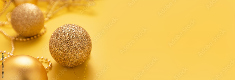 Christmas golden colored decorations on yellow background.