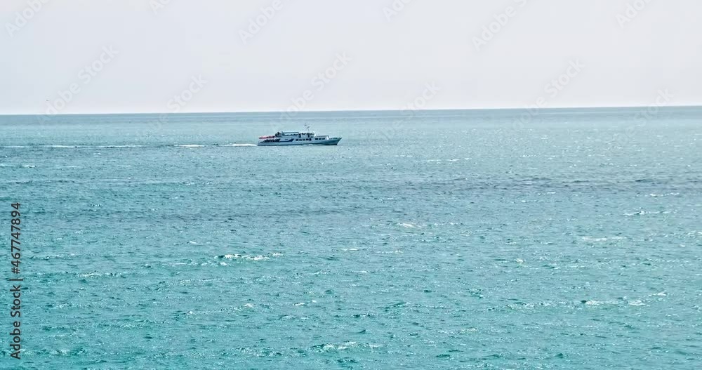 Blue turquoise sea with waves. View on sunny day to ocean. The water surface receding into distance, waves on the sea, ship is sailing along the sea. Blue water waves surface beautiful background Blue turquoise sea with waves. View on sunny day to ocean. The water surface receding into distance, waves on the sea, ship is sailing along the sea. Blue water waves surface beautiful background