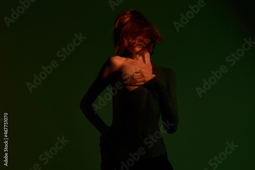 Girl with red hair posing on a green background