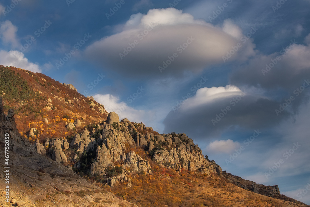 Clouds in the shape of UFO flying saucers over the mountain. Beautiful autumn evening landscape. Demerdzhi, Alushta, Crimea