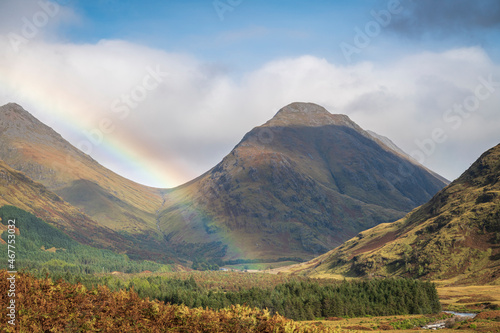 An autumnal 3 shot HDR image of a Rainbow in Glen Etive with Bauchaille etive Mor and Buachaille Etive Beag behind, Scotland.  photo