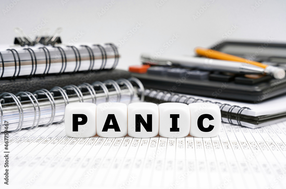 On the table, among office objects, cubes with the inscription - PANIC On the table, among office objects, cubes with the inscription - PANIC