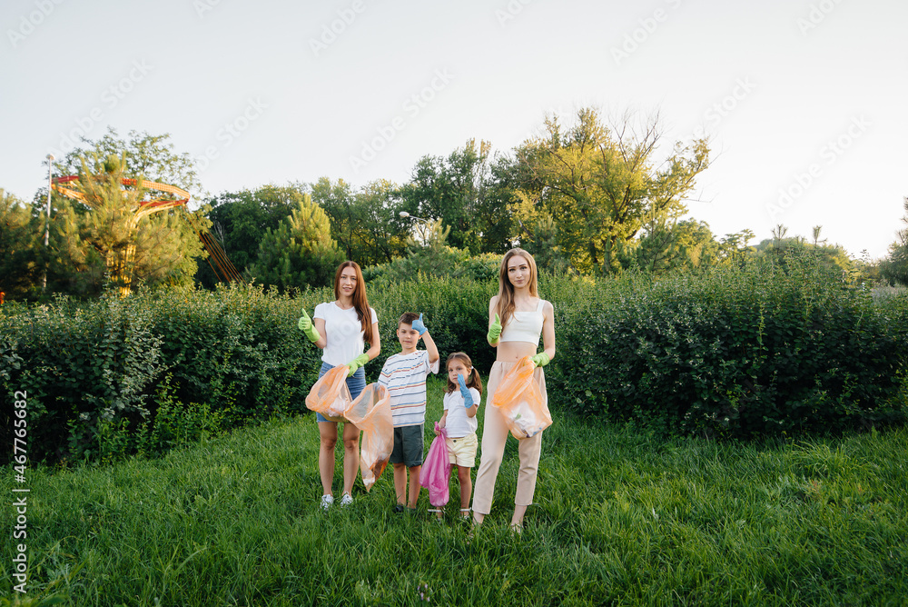 A group of girls with children at sunset are engaged in garbage collection in the park. Environmental care, recycling. A group of girls with children at sunset are engaged in garbage collection in the park. Environmental care, recycling.