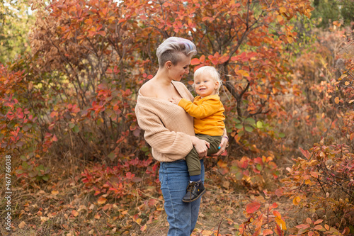 An adorable little boy with his mother in autumn park