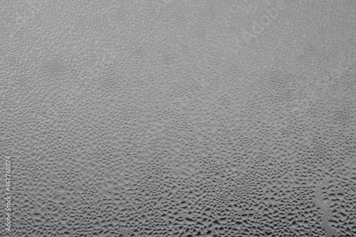 Raindrops on the window pane on a gray background. Natural pattern of raindrops. Texture for creativity. Water on the surface of the glass. photo
