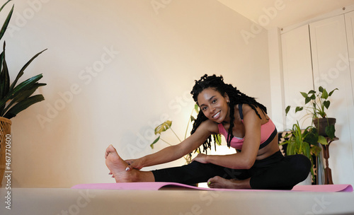 Attractive and healthy young black woman doing exercises while resting at home