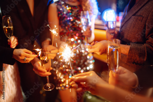 Sparkling sparklers in the hands. Playing firework to celebrate winter holidays with friends at the party. Magic New Year  Christmas.