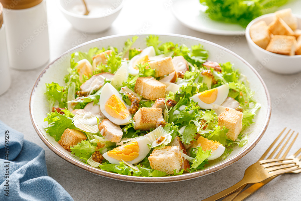 Caesar salad with grilled chicken breast, hard-boiled egg, croutons, parmesan cheese, green salad lettuce and dressing Caesar salad with grilled chicken breast, hard-boiled egg, croutons, parmesan cheese, green salad lettuce and dressing
