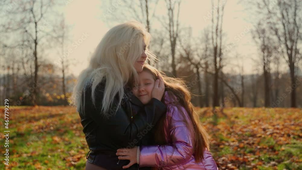 Mother and daughter hug in autumn forest park. Two females persons spend time together outdoors and show love and good relationships in family Mother and daughter hug in autumn forest park. Two females persons spend time together outdoors and show love and good relationships in family