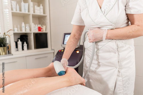 Hair removal on ladies legs. Laser epilation and cosmetology. Cosmetic beauty spa clinic. Cosmetology procedure from a therapist