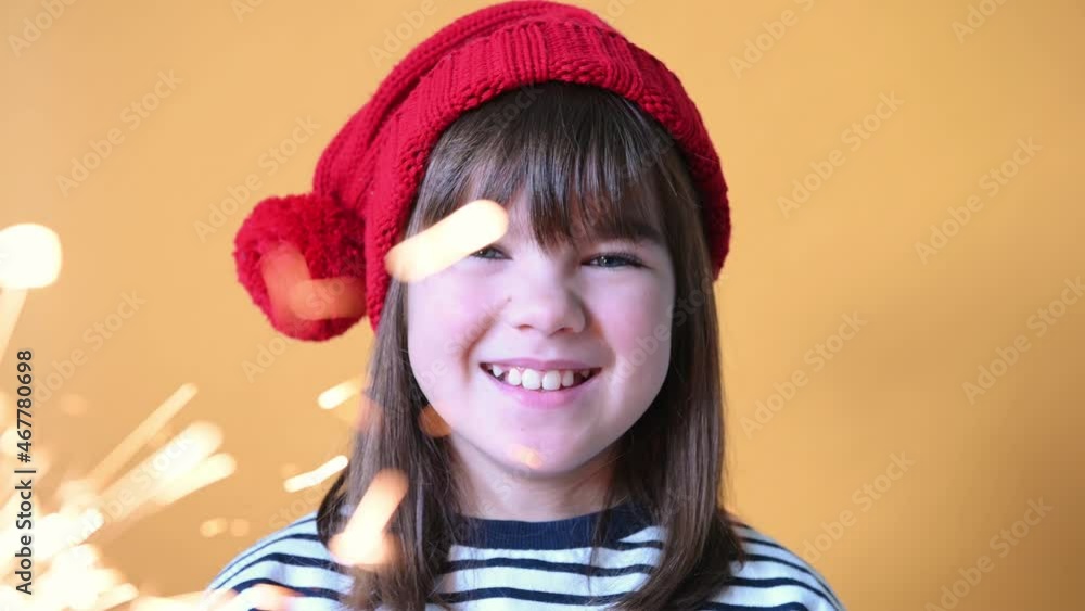 happy girl child in santa hat with sparklers on isolated yellow background christmas concept. High quality 4k footage happy girl child in santa hat with sparklers on isolated yellow background christmas concept. High quality 4k footage