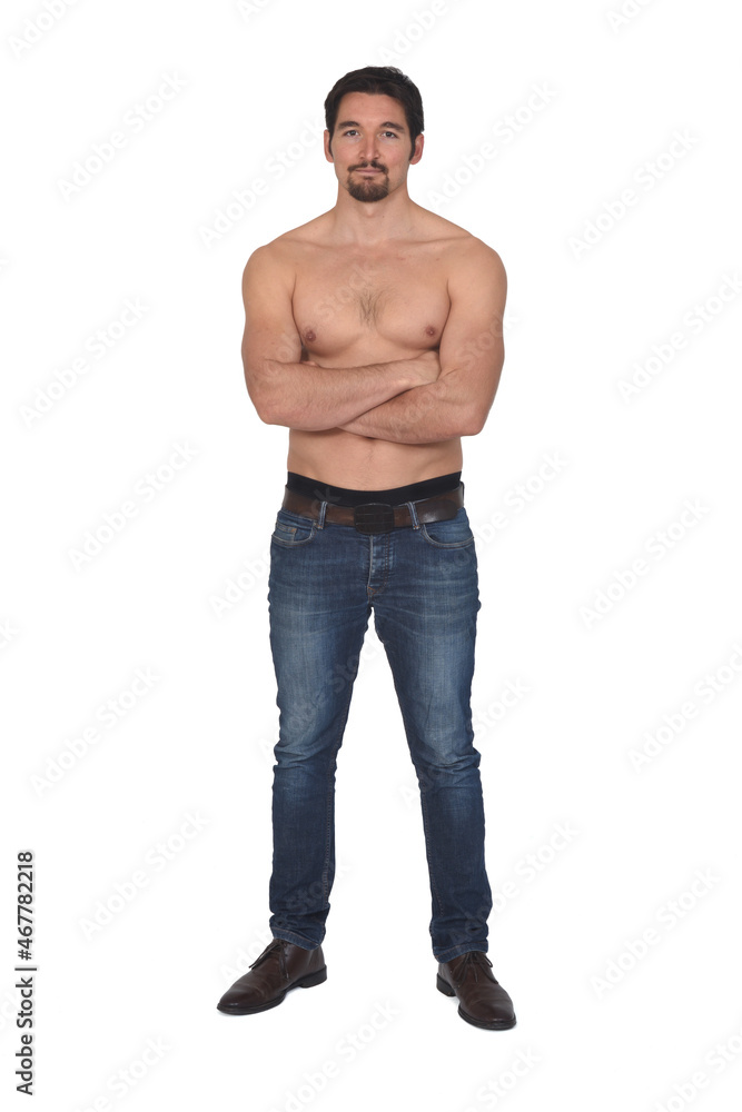 man shirtless and with blue jeans, arms crossed and looking at camera on white background man shirtless and with blue jeans, arms crossed and looking at camera on white background