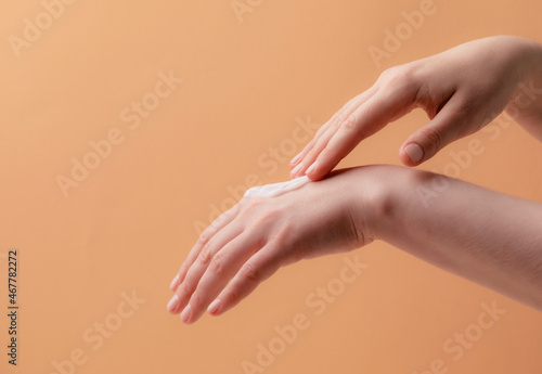 Young female hands applying cream or lotion