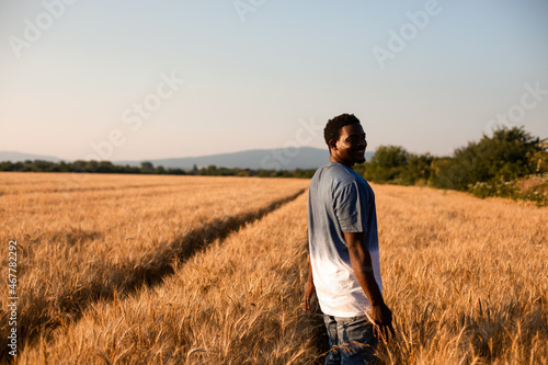 Young farmer standing in the middle of the field © oksix