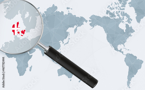 Asia centered world map with magnified glass on Denmark. Focus on map of Denmark on Pacific-centric World Map.