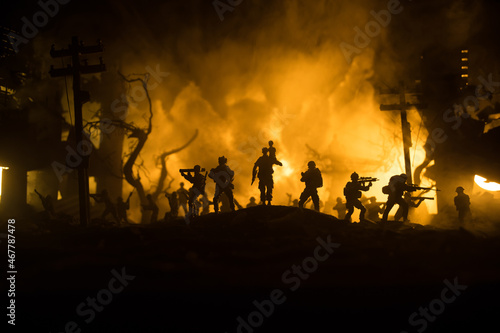 Silhouette of a man carrying injured girl from fire. Rescue savior concept. Military officer running out with woman from burned out city destroyed in war. Creative artwork decoration. Selective focus