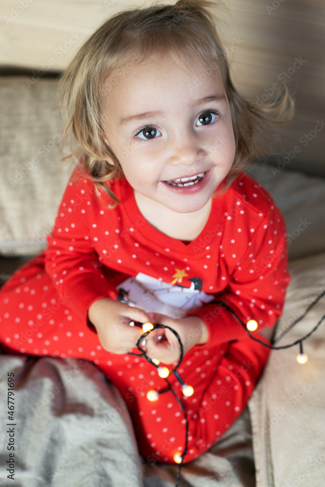 Christmas morning. Toddler girl red pajamas having fun in bed Christmas morning. Toddler girl red pajamas having fun in bed
