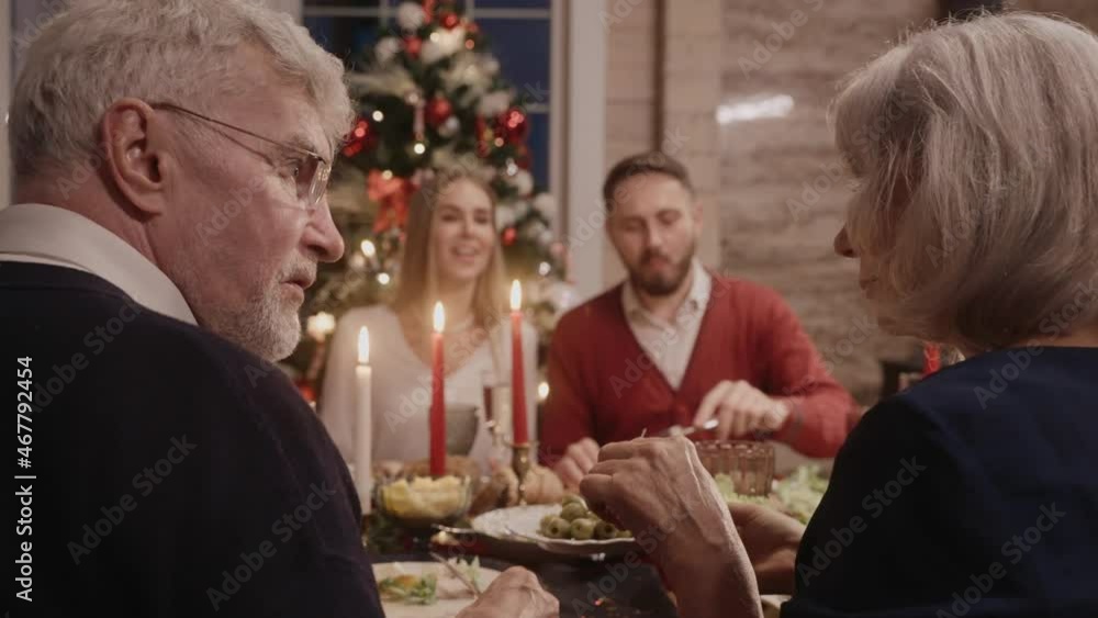 Whole family talking at the table on Christmas Eve, grandma serving the salad. Family gathering for Christmas celebration. 50fps. High quality 4k footage Whole family talking at the table on Christmas Eve, grandma serving the salad. Family gathering for Christmas celebration. 50fps. High quality 4k footage